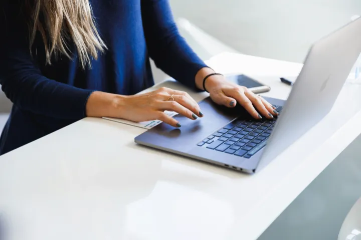 Person vid laptop hanterar kundkommunikation